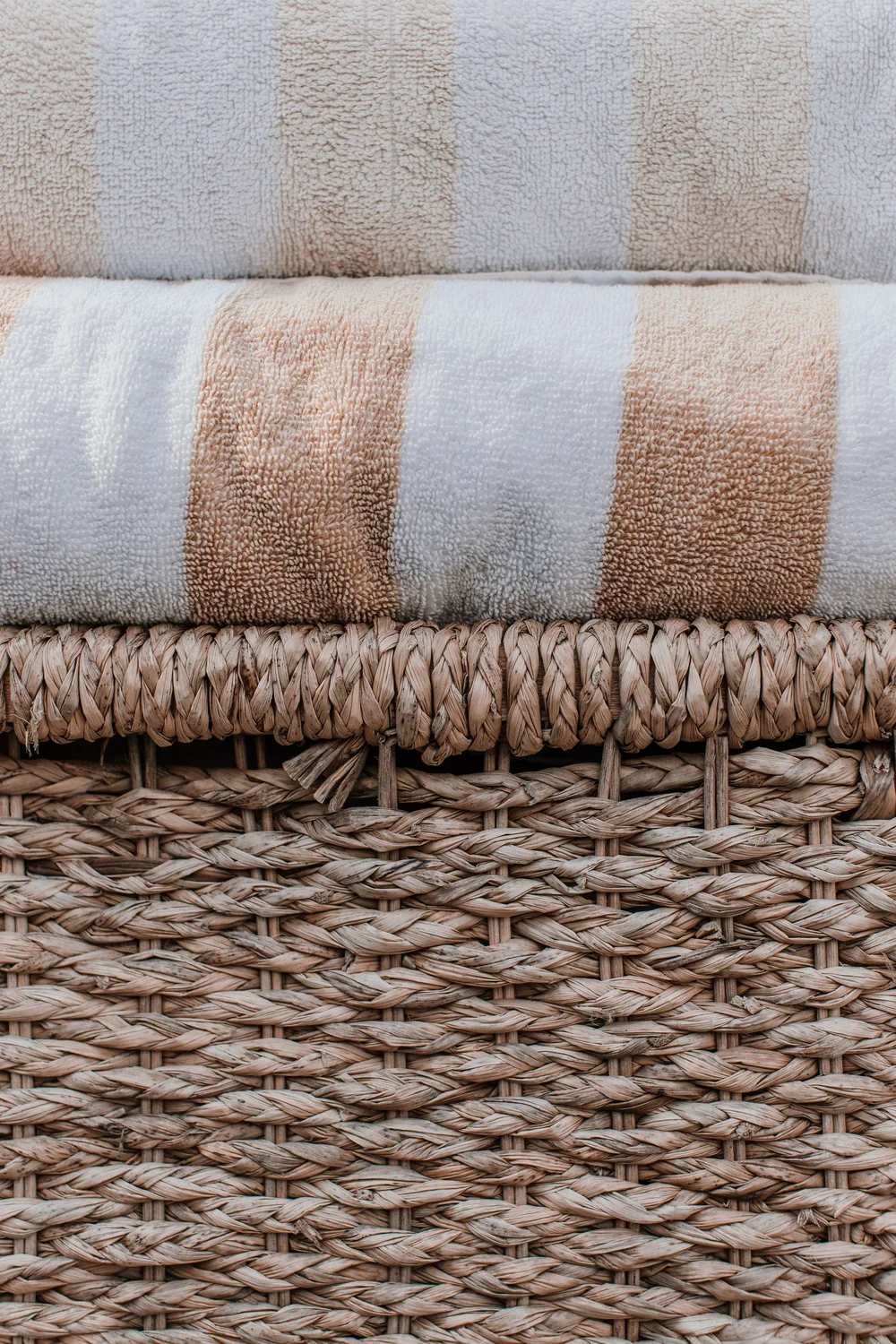 A close-up of clean cotton towels and a natural wicker basket